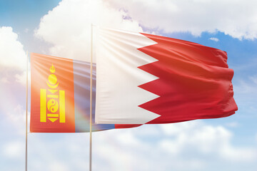 Sunny blue sky and flags of bahrain and mongolia