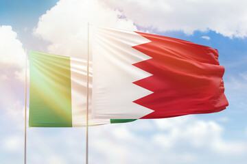 Sunny blue sky and flags of bahrain and nigeria