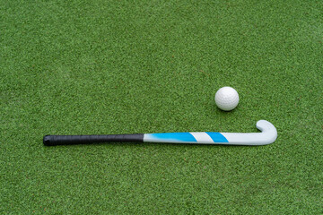 Field hockey stick and ball on green grass.  Horizontal sport theme poster, greeting cards, headers, website and app