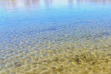 Clear water on the river bank. Background with selective focus and copy space