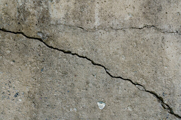 Cracked concrete slab. Wall made of cement with crack. House foundation repair. Texture surface or...