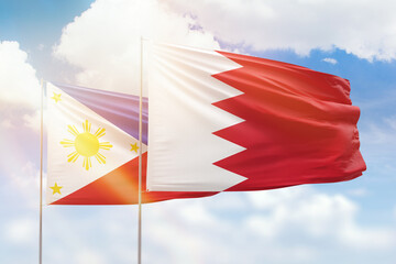 Sunny blue sky and flags of bahrain and philippines