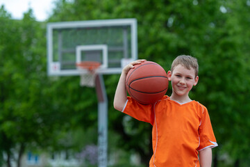 Boy playing basketball on a park court. Concept of a sports lifestyle, training, camp, leisure,...