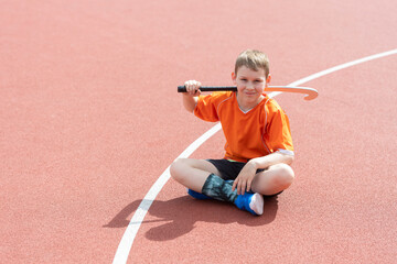 Boy playing field hockey with stick. Concept of a sports lifestyle, training, camp, leisure,...