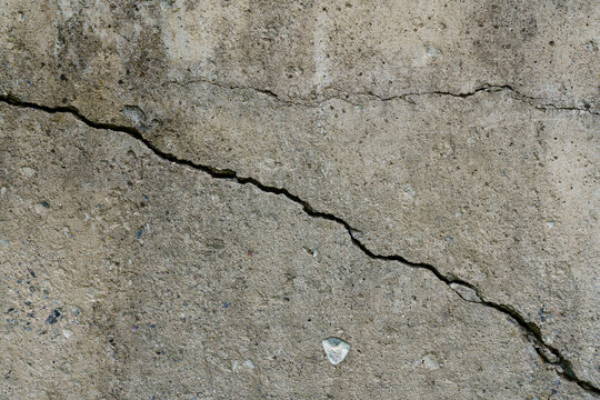 Cracked concrete slab. Wall made of cement with crack. House foundation repair. Texture surface or background