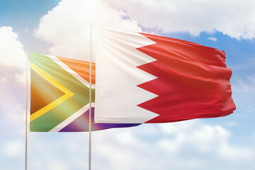 Sunny blue sky and flags of bahrain and south africa