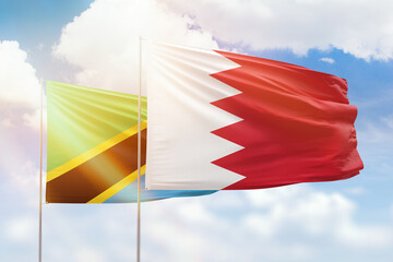 Sunny blue sky and flags of bahrain and tanzania