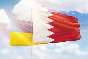 Sunny blue sky and flags of bahrain and ukraine