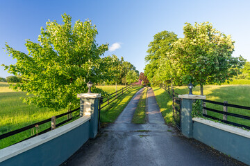 l'entrée d'un domaine, avec une route entourée de barrière en bois