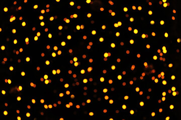 Christmas golden blurred bokeh lights on a black background. lights. Bright bokeh glow. Holiday concept with place for text.
