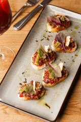 Four bruschettas with beef tartare on a plate, Crostini with Beef Tartare, beef Bruschetta, sandwich with raw gourmet beef.