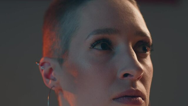 Pensive young girl fashion model with short hair, modern makeup looking aside, closeup studio portrait. ProRes codec