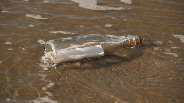 A message in a bottle washed up on the beach by waves