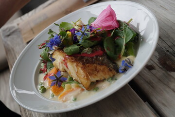 Buntes leckeres Gericht mit Blumen im Restaurant