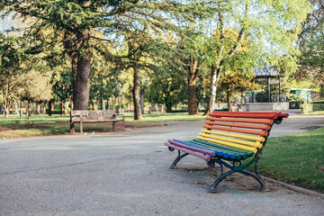LGBTQ rainbow painted bench in a park on sunny summer day as a support of LGBTIQ community