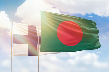 Sunny blue sky and flags of bangladesh and finland
