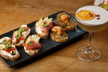 Bruschettas with vegetables. Start dishes with cherry tomatoes, avocado, cream cheese and shrimps. Food composition, tasty italian meal