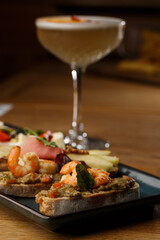 Bruschettas with vegetables. Start dishes with cherry tomatoes, avocado, cream cheese and shrimps. Food composition, tasty italian meal