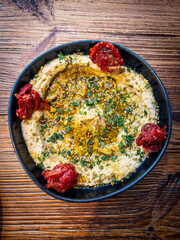 Hummus topped with sesame seeds, olive oil and chopped cilantro, typical dish in the Middle Eastern cuisine.