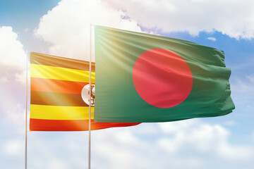 Sunny blue sky and flags of bangladesh and uganda