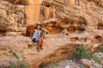 Woman sitting on a red rock