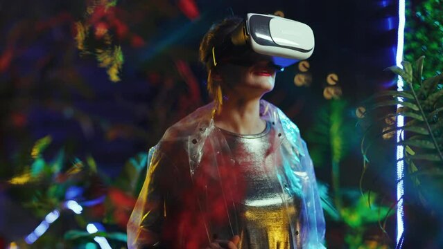 smiling stylish female in metaverse in vr goggles exploring.