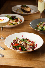 Salad with veal and tomatoes. Beef steak with raw vegetables mix side view. Grilled meat with...