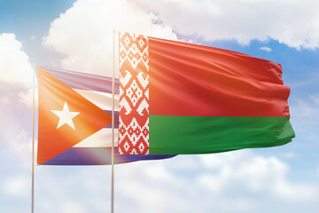 Sunny blue sky and flags of belarus and cuba