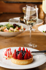 Berry tartlets with curd cream on a wooden background. Summer fruit baking. Tartlets with raspberries, blueberries and red currants. Served with ice cream.
