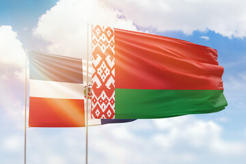 Sunny blue sky and flags of belarus and dominican republic