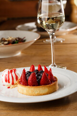 Berry tartlets with curd cream on a wooden background. Summer fruit baking. Tartlets with raspberries, blueberries and red currants. Served with ice cream.