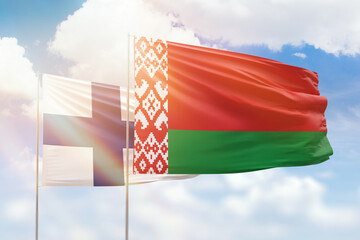 Sunny blue sky and flags of belarus and finland