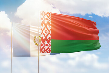 Sunny blue sky and flags of belarus and guatemala