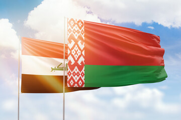 Sunny blue sky and flags of belarus and iraq