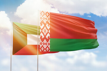 Sunny blue sky and flags of belarus and kuwait