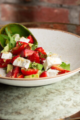 Tasty and healthy salad with arugula, brie cheese, avocado, cherry tomatoes and strawberry. Top view. The flat lay. Banner