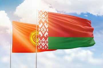 Sunny blue sky and flags of belarus and kyrgyzstan