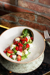 Tasty and healthy salad with arugula, brie cheese, avocado, cherry tomatoes and strawberry. Top view. The flat lay. Banner