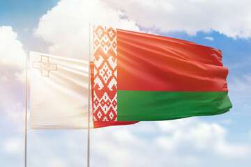 Sunny blue sky and flags of belarus and malta