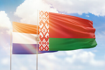 Sunny blue sky and flags of belarus and paraguay