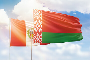 Sunny blue sky and flags of belarus and peru
