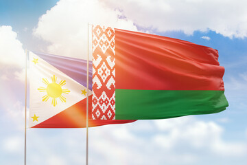 Sunny blue sky and flags of belarus and philippines