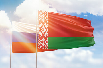 Sunny blue sky and flags of belarus and russia
