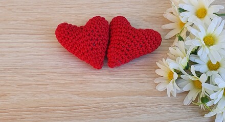 Obraz na płótnie Canvas Crochet flowers and hearts on wooden background.