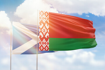 Sunny blue sky and flags of belarus and scotland