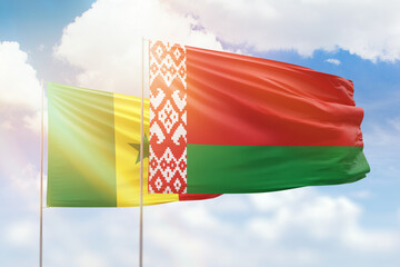 Sunny blue sky and flags of belarus and senegal
