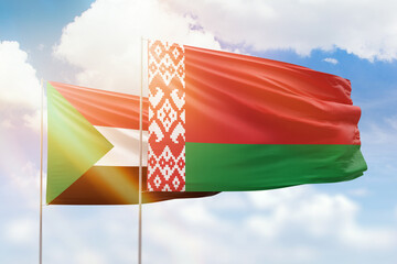 Sunny blue sky and flags of belarus and sudan