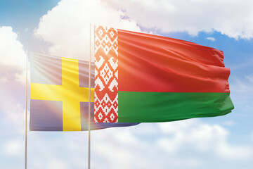 Sunny blue sky and flags of belarus and sweden