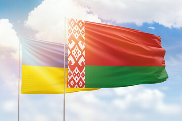 Sunny blue sky and flags of belarus and ukraine