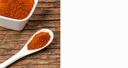 Red chili powder or paprika in ceramic bowl and spoon - Capsicum annuum